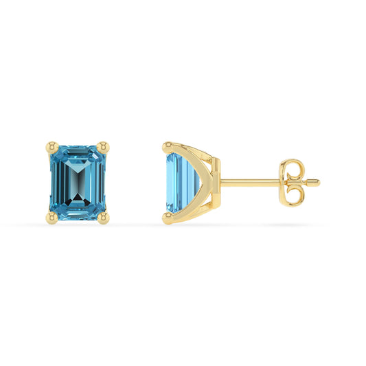 natural swiss blue topaz emerald cut stud earrings in yellow gold